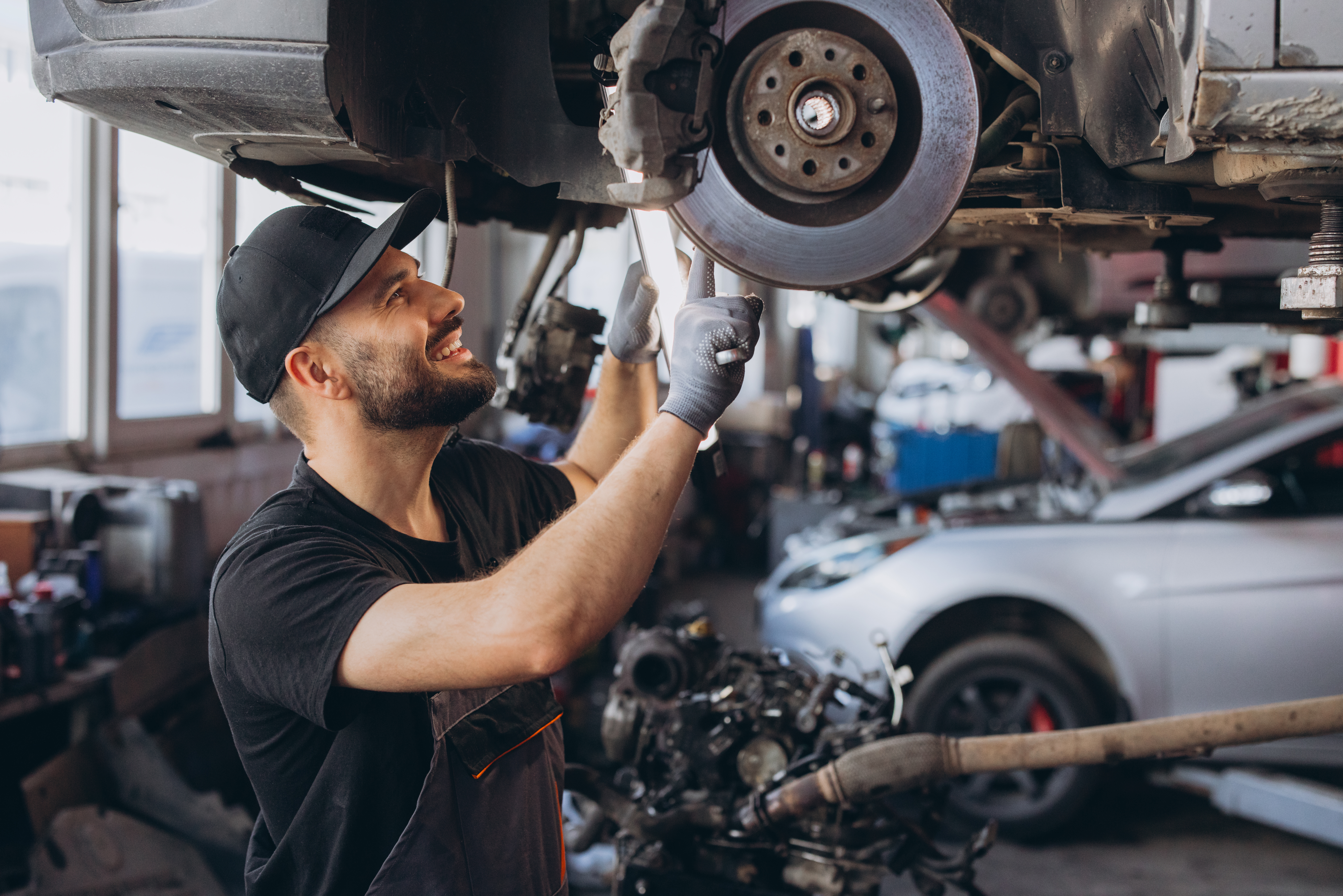 Mechanic inspecting car brake disc in an auto repair workshop, providing professional vehicle maintenance service